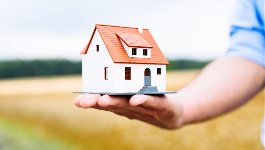 A man holding a 3D model of a house